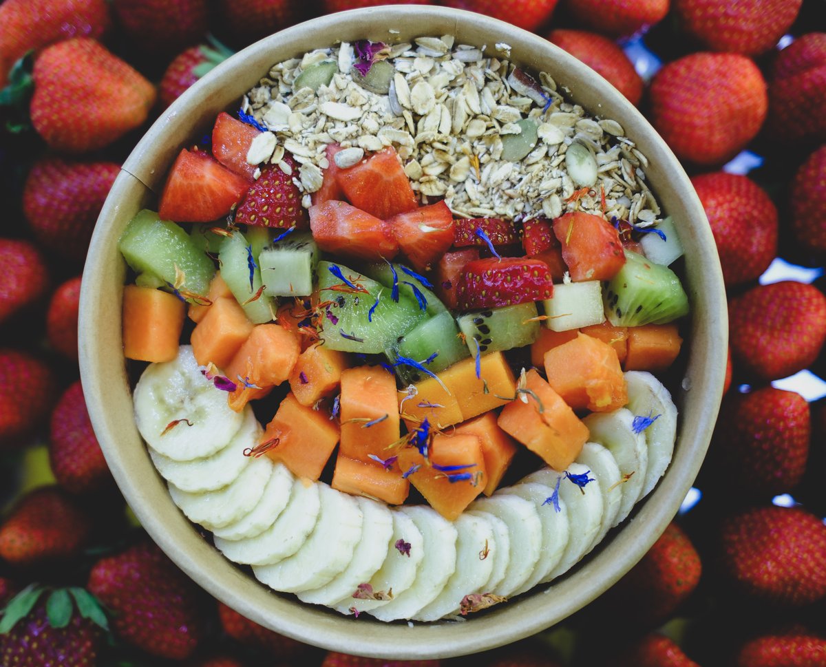 Bowl de açaí con fresas, plátano, kiwi, papaya y granola — toma cenital